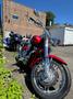 A 2007 Honda VTX1800F3 motorcycle in red with chrome accents positioned on a paved surface with visible wheels and handlebars