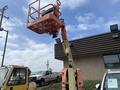 A 2009 JLG E300AJP aerial lift with an orange platform raised high above the ground and extended boom for access to elevated work areas