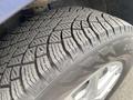 Close-up of a tire with detailed tread pattern mounted on a silver wheel designed for a 2022 Chevrolet Equinox