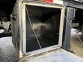 An empty storage compartment on a 2010 International 4300 truck with an open door and metal frame visible inside