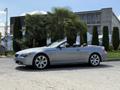 A silver 2004 BMW 6-Series convertible parked with its top down showcasing sleek lines and alloy wheels