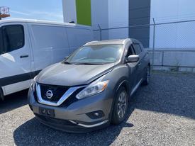 A gray 2017 Nissan Murano parked in an outdoor area with a sleek design featuring a prominent front grille and stylish headlights