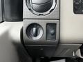 Close-up of the control panel in a 2009 Ford F-550 featuring a round dial for headlights and a switch for additional lighting