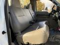 The interior of a 2008 Ford F-550 featuring a spacious front bench seat in gray vinyl with seatbelts and minimal controls visible near the dashboard