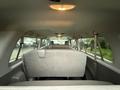 Interior view of a 2013 Ford E-350 with gray upholstery and multiple seating rows facing forward