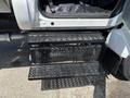 A close-up view of the steps leading into a 2015 Ford F-750 truck with perforated metal surfaces for traction and grip