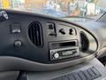 The interior dashboard of a 2002 Ford Econoline featuring air vents control knobs and a car stereo