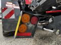 Close-up of a 2020 Pottinger Impress agricultural machine's rear light assembly featuring red and amber lights with warning and hazard markings