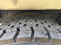 Close-up of a 2010 Freightliner M2 106 tire showing deep treads with some dirt and debris embedded in the rubber