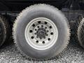 Close-up of a large wheel and tire from a 2018 Kenworth T800 featuring a silver rim with multiple lug nut bolts and a Yokohama tire with tread visible on the surface