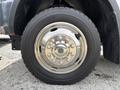 Close-up of a shiny chrome wheel rim with multiple bolts and a rugged tire tread from a 2016 RAM 5500