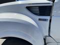 Close-up of a 2014 International TerraStar truck's front fender featuring the MaxxForce badge and ventilation grille in white color