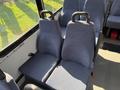 Interior view of a 2017 Chevrolet Express showing two blue fabric seats with metal armrests and seat belts