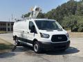 A white 2019 Ford Transit 350 van with a high roof and an elevated work platform on top parked in a lot
