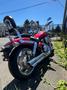 A red 2007 Honda VTX1800F3 motorcycle with chrome exhaust pipes and a chrome rear seat backrest positioned on a concrete surface