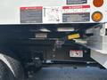 A 2019 Freightliner M2 106 truck with a prominent yellow lever and various warning labels related to electrical hazards and operational safety