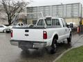 A white 2008 Ford F-250 Super Duty pickup truck with a ladder rack visible on the bed and black tires