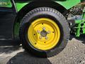The image shows a close-up of a yellow and black wheel from a 2021 John Deere 1575 mower with visible treads and bolts in the center.