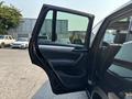 A 2013 BMW X3 with the driver's door open revealing the interior and seating arrangement