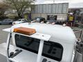 A white 2016 Peterbilt 348 truck featuring an amber light on top and multiple chrome lights along the cab roof