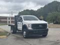 2023 Ford F-450 Super Duty with a flatbed in front view showcasing its robust design and large wheels