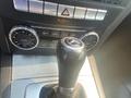 The image shows the gear shift and control panel of a 2013 Mercedes-Benz C-Class with buttons for various driving modes and climate control settings