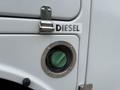 A close-up of a 2008 Ford F-450 SD fuel door with a green diesel fuel cap and a label that says DIESEL