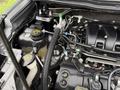 Engine compartment of a 2019 Ford Explorer featuring various components like hoses batteries and fluid reservoirs