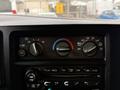 The climate control panel of a 2004 Chevrolet Express featuring knobs for temperature fan speed and air conditioning settings