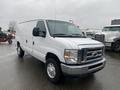 A white 2011 Ford Econoline van with a clean design and high stance, featuring large side mirrors and no rear windows