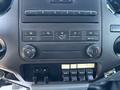 Dashboard controls of a 2011 Ford F-550 featuring climate control knobs and auxiliary switches