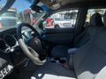 Interior view of a 2010 Toyota Tacoma featuring a steering wheel gear shift and fabric seats