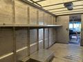 A 2018 Ford Econoline van with an interior featuring metal walls and shelves along the sides