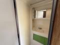 Interior view of a compact bathroom with a sink and mirror in a 1976 GMC Motorhome