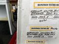 A 2006 Ford Econoline van with multiple inspection and service stickers displayed on the side