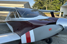 A 1986 Sorrell Hiperbipe SNS-7 amateur-built aircraft with a sleek design featuring a maroon fuselage and metallic front engine components