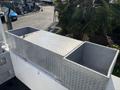A metallic diamond plate tool box with two compartments on a truck bed