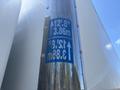 A metal pole displaying height measurement stickers for a 2020 Hino 338 with values of 12.8 feet and 3.86 meters