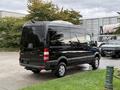 A 2017 Mercedes-Benz Sprinter van in black parked at an angle with its rear view visible