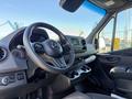 Interior of a 2023 Mercedes-Benz Sprinter 2500 showing the steering wheel dashboard and center console with cup holders and controls