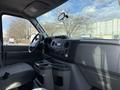Interior view of a 2011 Ford Econoline showing the driver's seat dashboard and console with controls and cup holders