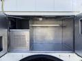 An open compartment of a 2008 International 4400 with metal walls and shelves designed for storage and utility purposes