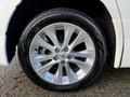 Close-up of a silver alloy wheel of a 2009 Toyota Vellfire featuring multiple spokes and a branded center cap with a black tire