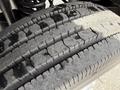 Close-up of a worn tire from a 2008 Ford F-550 showing uneven tread wear and surface moisture