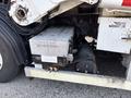 A metal compartment with a diamond plate exterior and a warning label saying DO NOT STEP located under the chassis of a 2011 Autocar Xpeditor