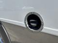 Close-up of the fuel fill opening on a 2020 Chevrolet Express with a circular metal cap and a black plastic nozzle inside