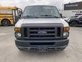 A 2010 Ford Econoline van is displayed head-on with a gray body and a prominent black grille featuring the Ford logo