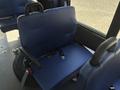 A blue upholstered seat with armrests and a seatbelt, part of a vehicle interior designed for passenger safety and comfort