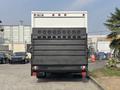 A 2008 Ford Econoline truck with a black rear loading door featuring circular cutouts and reflective lights on top