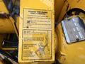 A close-up of a yellow warning label on machinery with text instructing maintenance and safety procedures related to a 1993 Bandit 200+ wood chipper